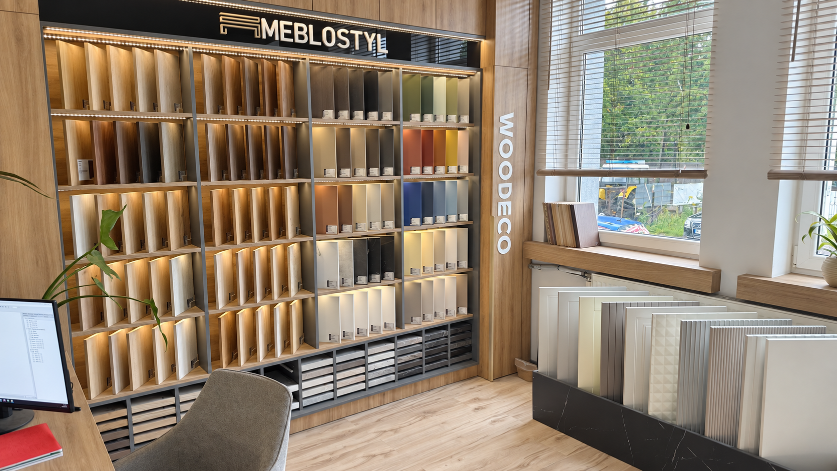 Showroom MebloStyl w Piszu: podświetlona ekspozycja wzorników płyt i frontów meblowych